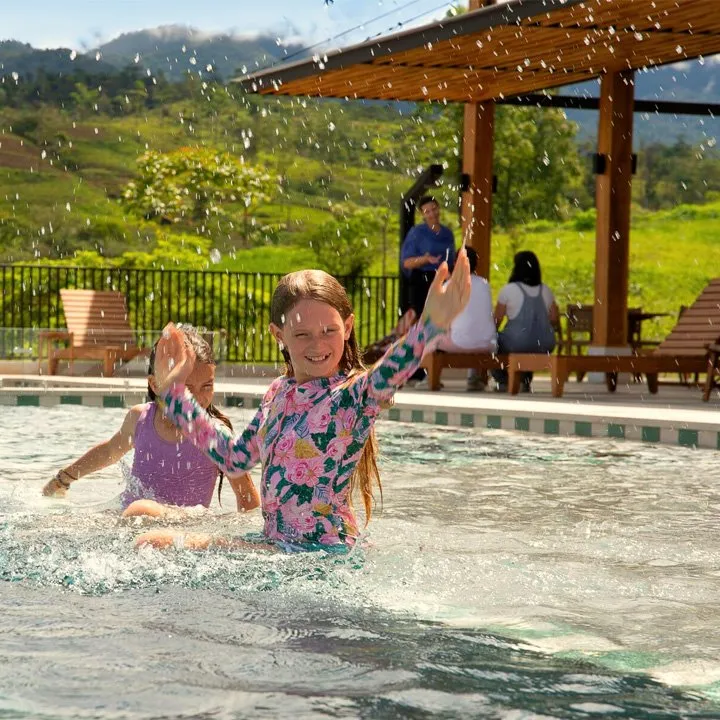 RISE Costa Rica saltwater infinity pool surrounded by tropical landscaping with mountain views