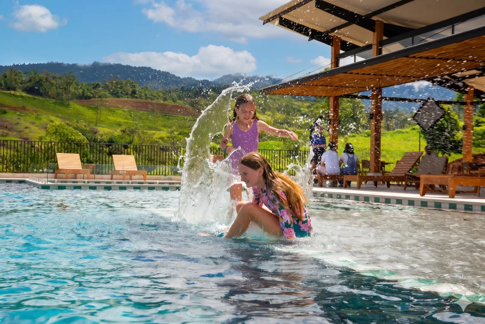 Kids playing in the RISE Costa Rica community pool with mountain views and pergola